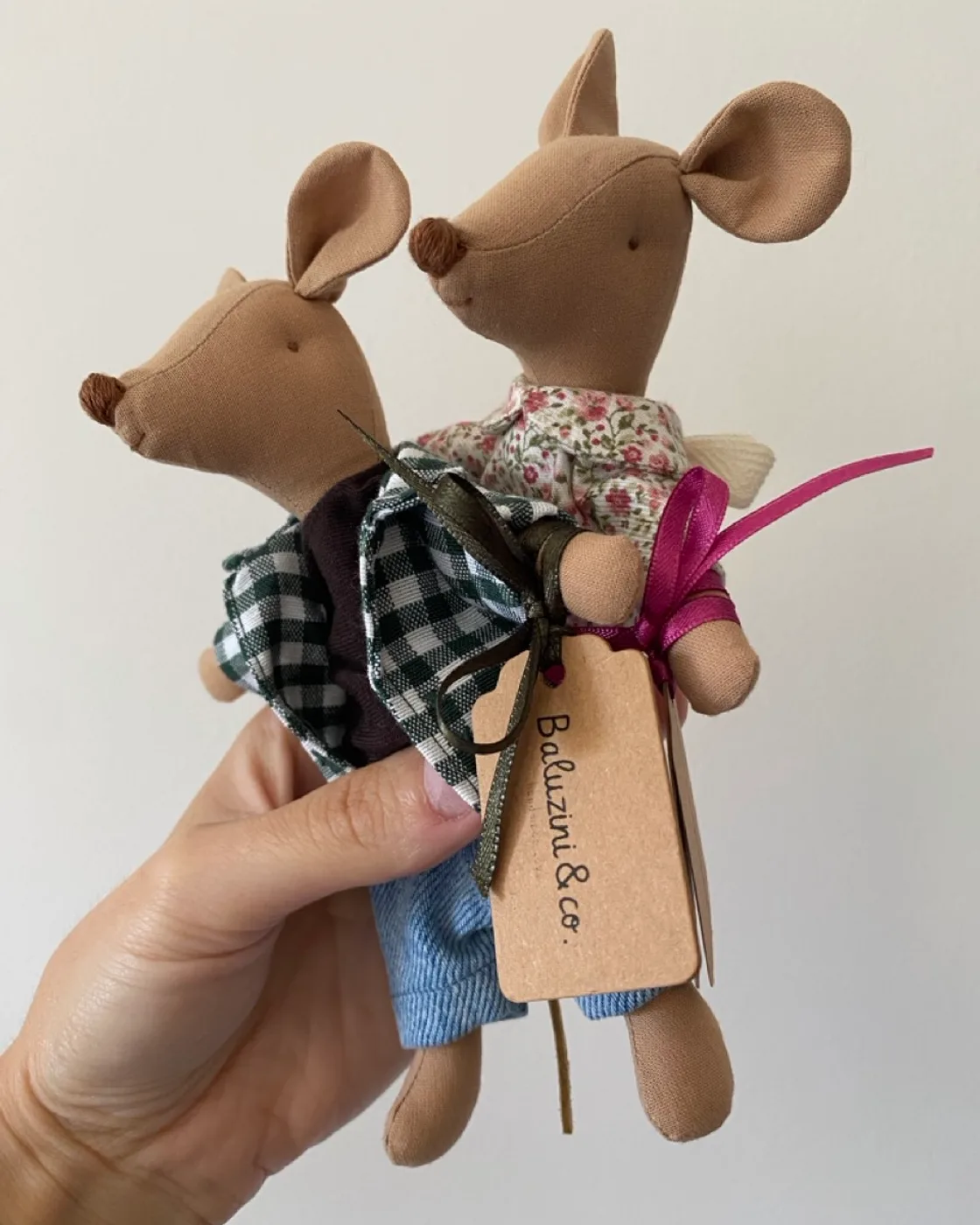 Two Baluzini mice in hand, with the atelier tag.